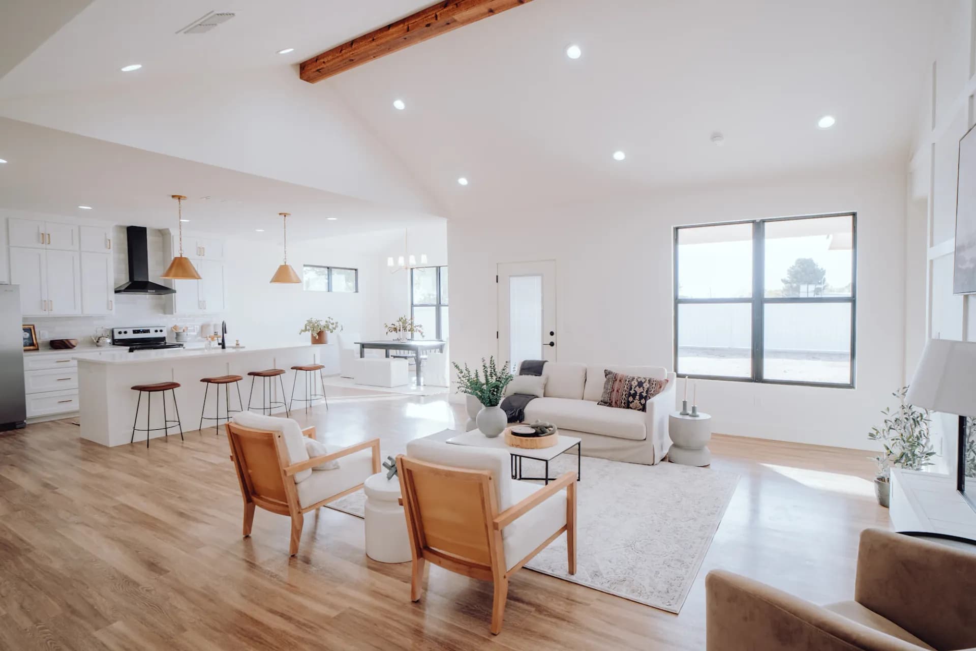 A bright, open-plan living room with white sofa, vaulted ceiling and abundant natural light, professionally cleaned by Wonderful Laura Cleaning
